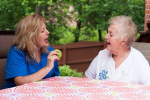 Apraxia of speech is one of several types of speech disorders. In this image, a therapist is helping a stroke victim pronounce the word "apple."