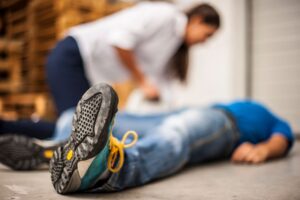 A woman assists a man lying on the ground. It's important to understand what to do if someone has a seizure.