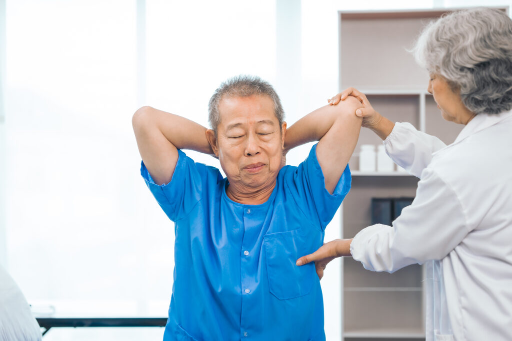 Elderly man receiving physical therapy for stiffness, an early sign of Parkinson’s disease