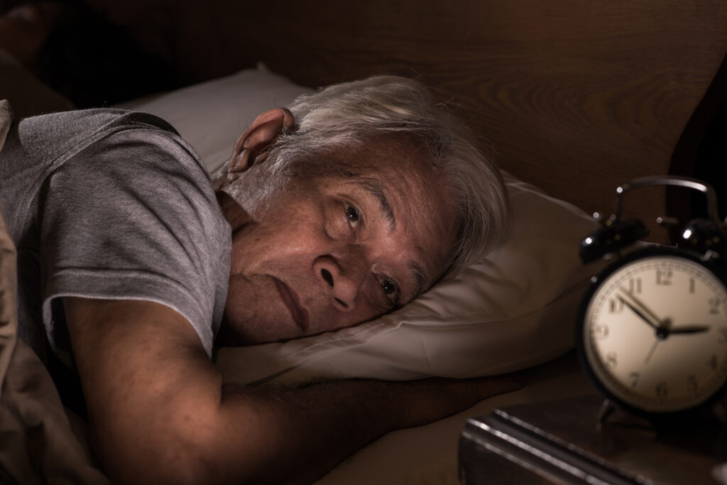Man struggling with sleep disturbances, a common early sign of Parkinson’s disease